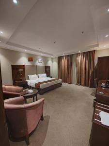 吉赞فندق تـاج النخبة - Taj Nakhba Hotel的酒店客房配有一张床、一张沙发和椅子。