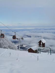 霍茨科波霍尔耶Luxury apartments Prežin的雪覆盖的山上的滑雪缆车和小屋