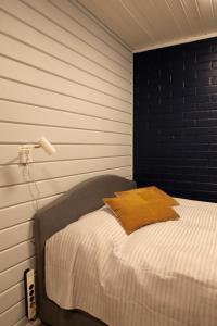 易拉斯加威Yllästokka 10的一间卧室配有一张黑色墙壁的床