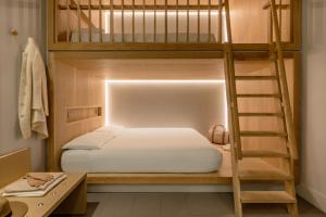 伦敦Zedwell Piccadilly Circus的一间卧室设有两张双层床和梯子