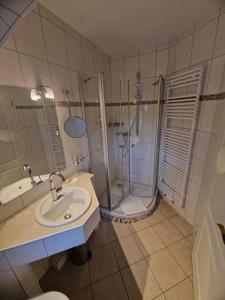 内贝尔Inselhotel Kapitän Tadsen / Amrum的带淋浴、盥洗盆和卫生间的浴室