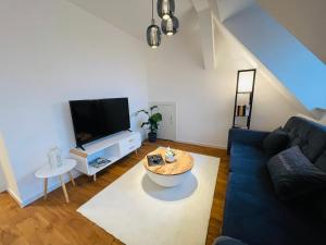 伍珀塔尔ruhig-Nespresso-Netflix-Parken-luxuriös的客厅配有蓝色的沙发和电视