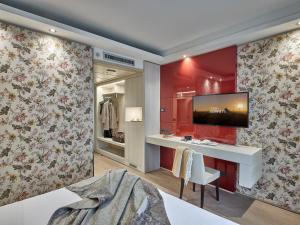 格拉索比奥贝加莫机场冬季花园酒店的卧室设有红色的墙壁,墙上配有电视