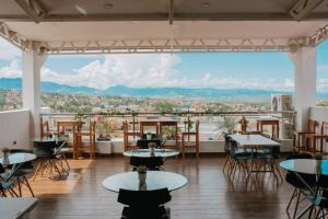 塔拉波托Palm Hotel Tarapoto的一间带桌椅的市景餐厅
