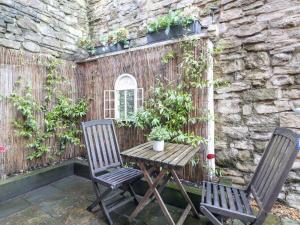 阿什伯恩Poppy Cottage的庭院设有两把椅子和一张木桌