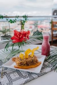 塔拉波托Palm Hotel Tarapoto的花瓶旁边的桌子上放着一盘食物