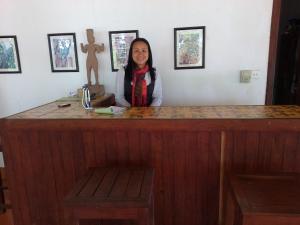 桔井阿伦湄公宾馆的女人站在木柜台后面