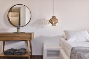 阿波罗尼亚咖里斯别墅酒店的一间卧室配有一张床和一张带镜子的桌子