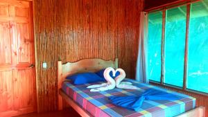 德雷克Encanto Lodge的两个天鹅坐在一个房间里的床边