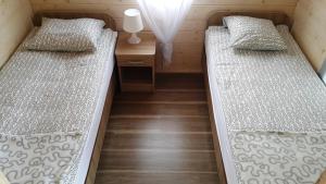 特兹萨茨Sielankowo Trzęsacz的小型客房铺有木地板,配有两张床。