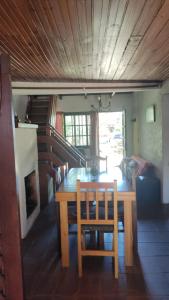 拉帕洛马Casa en Barrio Country - La Paloma的一间带木桌和椅子的用餐室