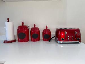 迪斯卡弗里贝2 BR Gated Community Secured Home的一组红色的烤面包机和柜台上的烤面包机