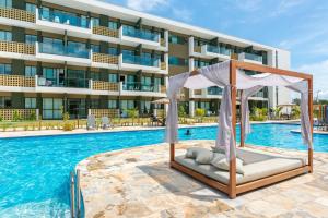 嘎林海斯港Mana Beach Experience Muro Alto por Brevelar的一座酒店游泳池,在一座建筑前设有一张床