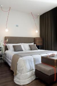 佛罗伦萨尤尼科莫酒店的卧室配有一张白色的大床和一张沙发。
