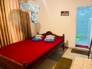 代尼耶耶Sinharaja Tour Hostel的一间卧室配有一张红色的床和淋浴