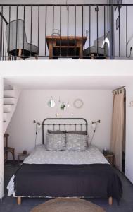 滨海萨纳里Maison d hôtes LA VILLA MADELEINE的卧室两张图片,卧室配有一张床和一个楼梯