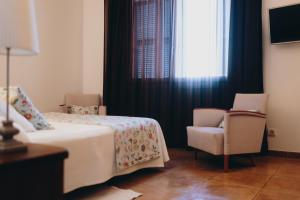 锡内乌Can Serrete的卧室配有床、椅子和窗户。
