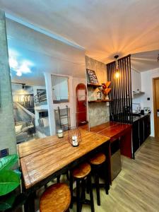 塔里萨伊Antara-QueenBed-Balcony-HotShower-WorkCoffee Station-FullKitchen的厨房配有一张大木桌和凳子