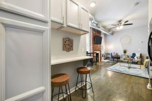 匹兹堡HostWise Stays - The James Apt 1 - Patio, Free Street Parking的一间客厅,客厅里设有酒吧和凳子