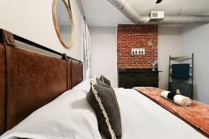 匹兹堡HostWise Stays - The James Apt 1 - Patio, Free Street Parking的一间卧室设有一张大床和砖墙