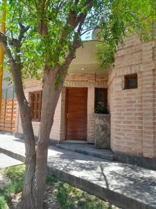 贝伦Alojamiento Belen Catamarca的树旁的砖砌建筑,木门