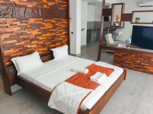 BijiloKasumai Beach Resort的一间卧室配有一张大床和一台平面电视