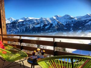 贝阿滕贝格Hotel Gloria的雪覆盖的山景阳台上的桌椅