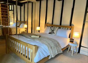 查尔伯里China Cottage - Quaint, Cosy, Cotswolds Retreat的一间卧室配有一张木架大床