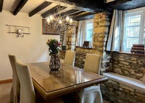 查尔伯里China Cottage - Quaint, Cosy, Cotswolds Retreat的一间带木桌和椅子的用餐室