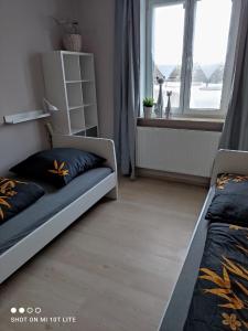 维斯马Ferienwohnung Henny的一间卧室设有两张床和窗户。