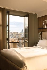巴黎Hôtel Dame des Arts的酒店客房设有一张床和一个大窗户