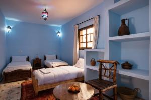 伊姆利尔伊姆利勒旅舍的蓝色的客房配有两张床和一张桌子