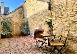 查尔伯里China Cottage - Quaint, Cosy, Cotswolds Retreat的天井配有桌椅和花瓶