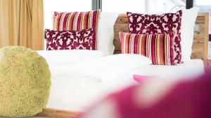 斯图加特科雷尔林德餐厅酒店的一张带色彩缤纷的枕头的白色床和一张沙发