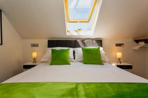 Bishops TawtonBISHOPS TAWTON SNOWDROP COTTAGE 3 Bedrooms的卧室配有带绿色枕头的大型白色床