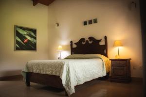 迪坡斯特兰Posada La Presa的一间卧室配有一张大床和两盏灯。