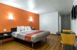 安纳海姆Beachside Inn的一间卧室配有一张橙色墙壁的床