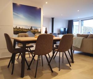 马尔梅迪Aux 4 vents - Malmedy的一间带木桌和椅子的用餐室