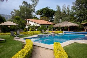 迪坡斯特兰Posada La Presa的庭院内的游泳池,配有椅子和遮阳伞