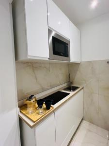 瓦雷泽Suite del Ponte的白色的厨房配有水槽和微波炉