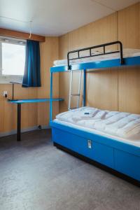 威廉港ARCONA - Übernachten auf dem Wasser - direkt am Bontekai的客房设有两张双层床和一张书桌。