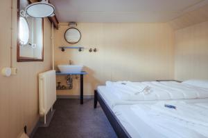 威廉港ARCONA - Übernachten auf dem Wasser - direkt am Bontekai的客房设有两张床、一个水槽和镜子