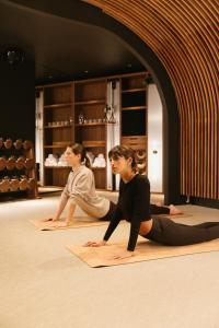 巴黎Hôtel Dame des Arts的两个坐在地板上参加瑜伽课的女人