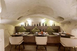 马泰拉Le Malve Cave Retreat的一间带桌子和白色椅子的用餐室