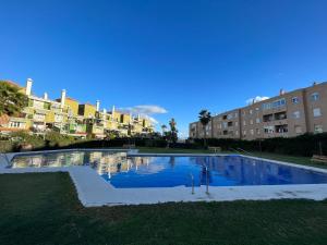 马拉加-MalagaSunApts-WEST Malaga Amazing SeaView的一座大型游泳池,其建筑背景为: