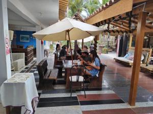 曼克拉拉波萨达酒店的一群人坐在桌子上,在伞下