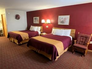 EmmetsburgAmericas Best Value Inn Suburban的酒店客房,配有两张床和椅子