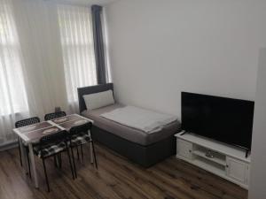 科隆Wohnung in Köln 1B的小房间设有一张床和一台平面电视