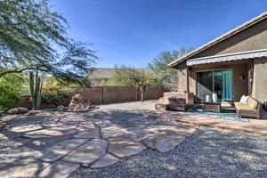 Gold CanyonGold Canyon House with Superstition Mountain Views!的坐在房子旁边的院子中的人