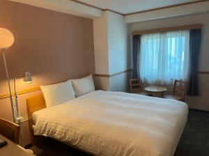 釜山釜山西面托优克酒店的酒店客房配有床、桌子和灯具